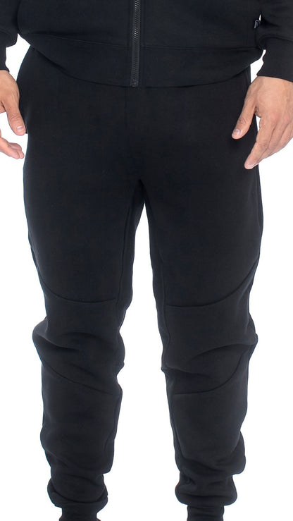 Relaxed fit fleece joggers in black, worn with sneakers for an athletic look.