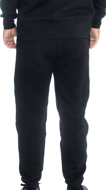 Relaxed fit black sweatpants shown from behind, featuring ribbed ankle cuffs