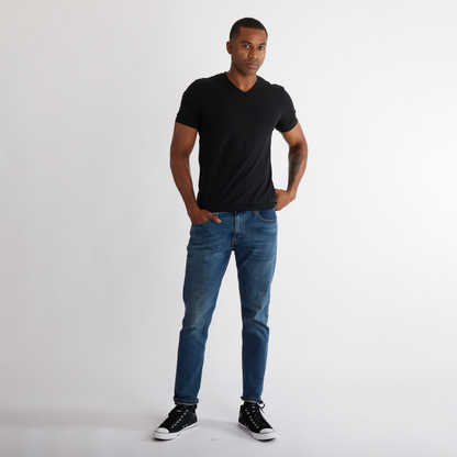 Man wearing a black t-shirt and blue jeans 